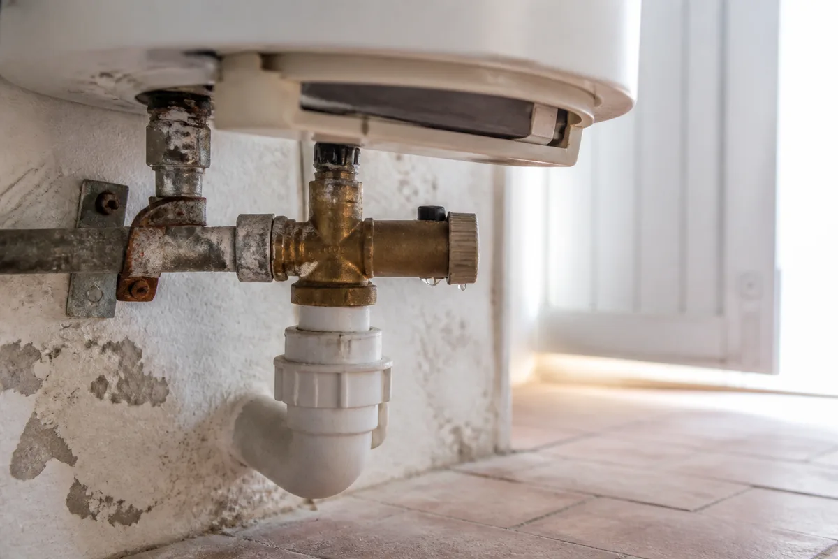 Ballon d’eau chaude électrique et son groupe de sécurité dans un local technique de villa arcachonnaise