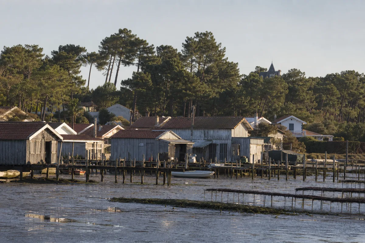 Toitures basses en tuile canal et cabanes ostréicoles en bois gris au bord du Bassin d’Arcachon